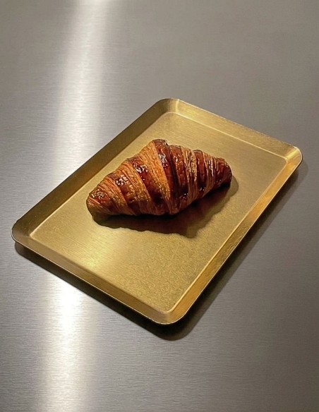 Bandeja de aluminio dorado con un cruasán